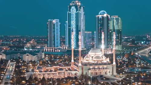 Lights Shining On City Buildings At Dusk