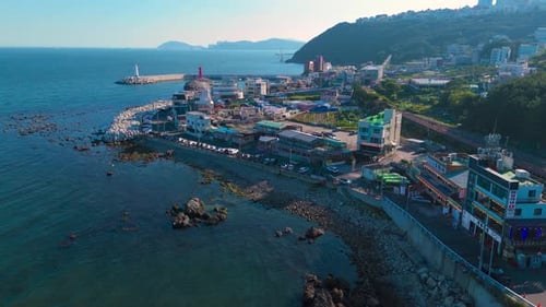 Cidade costeira aérea com farol vermelho e quebra-mar que se estende até o oceano Coreia do Sul