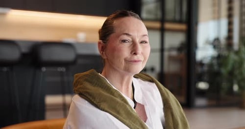 Smiling Woman with Brown Hair Poses in Office Setting