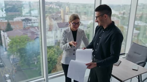 Positive relaxed colleagues talking and laughing in office.