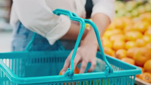 Shopping With a Blue Basket While Selecting Fresh Fruits in a Grocery Store Supermarket Close Up