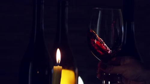 Wine Swirling in Glass with Candle Light at Night