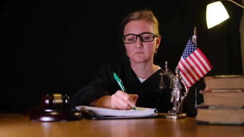 Woman Judge Writing Notes in Courtroom at Night