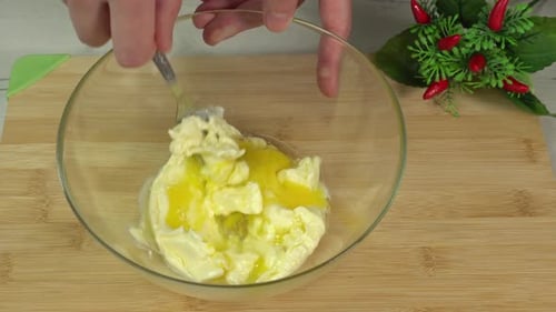 Mixing Eggs and Cream Cheese in Glass Bowl