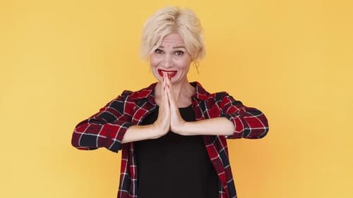 Adult Woman Pleading Against a Yellow Background