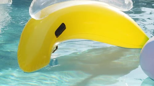 Uma piscina em forma de banana flutuante desliza pela água em câmera lenta