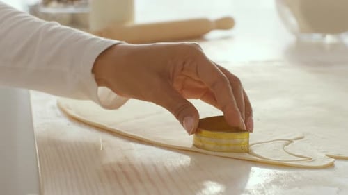 Hand Using Cookie Cutter on Dough