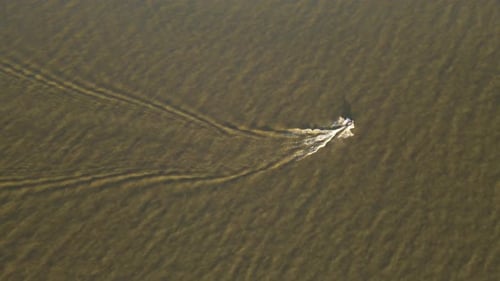 Luftaufnahme eines Jetskis von oben nach unten, der sich auf dem See bewegt