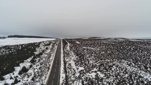 Lange Straße, Luftaufnahme in die Ferne, durch verschneite Hochlandschaften, Moore, abfallender Schuss