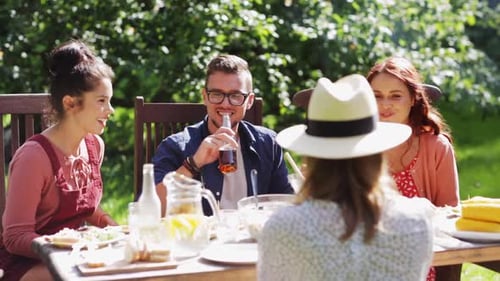 Friends Enjoying Outdoor Meal and Drinks Together