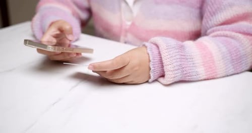 Close-up woman's hand holds a smartphone and use a mockup Bank credit card for online shopping servi