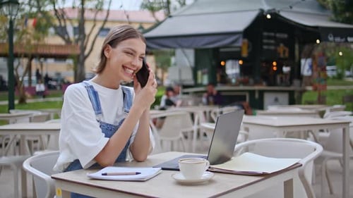 Cheerful Girl Talking Mobile Phone Sitting Outdoors Cafe with Laptop Closeup