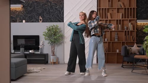 Two Young Women Dancing Together in a Living Room