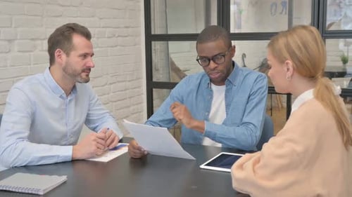 Diverse Team Collaborating on Project in Modern Office