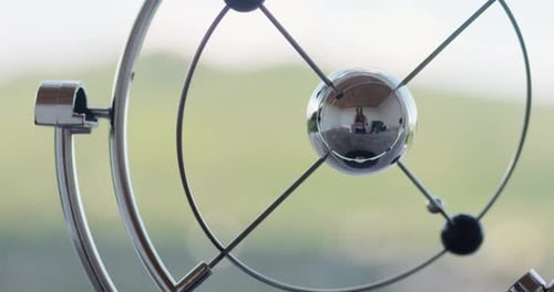 Perpetual Motion Sculpture Reflection of Adult Indoors