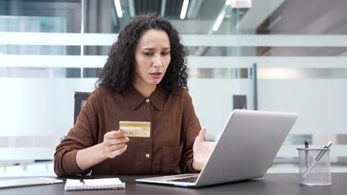 Frustrated Woman Holding Credit Card in Office
