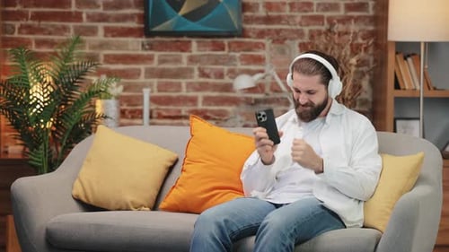 Man With Headphones Listening to Music On Phone