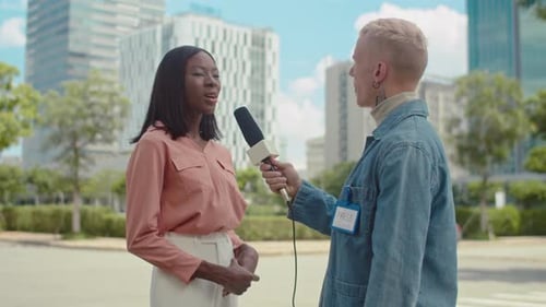 Reporter Interviewing Woman Outdoors in City Setting