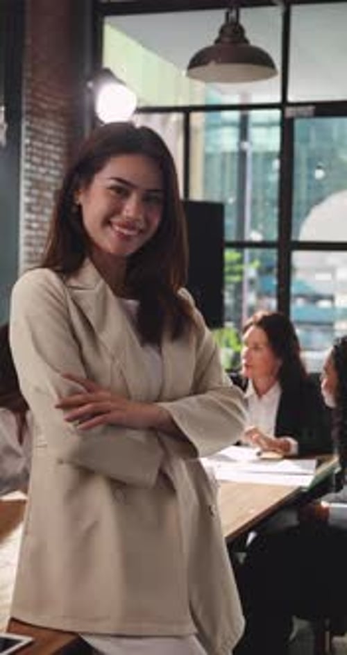 Confident Woman Smiles in Office with Colleagues