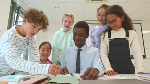 Teacher Explains Lesson to Group of Eager Students
