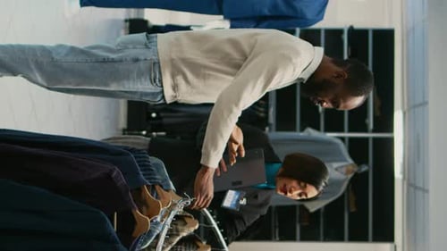 Vertical Video Asian Woman Showing Shirts to Male Client in Mall Store