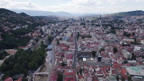 Aerial: Sarajevo, Bosnia and Herzegovina, with river, mosque, and cityscape