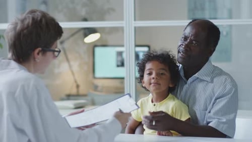Dad with Child on Consultation in Pediatric Clinic