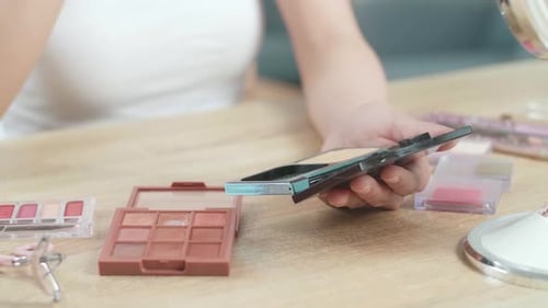 Woman Applies Makeup with Sponge Applicator