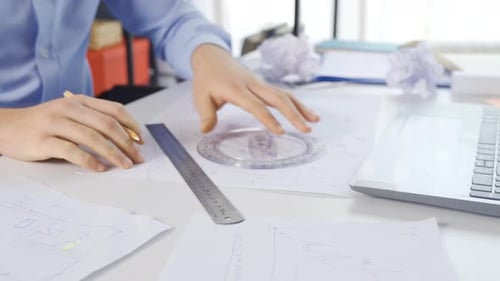 Architect Working on Plans at a Desk