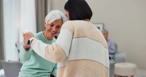 Senior Woman Dancing with Young Adult at Home