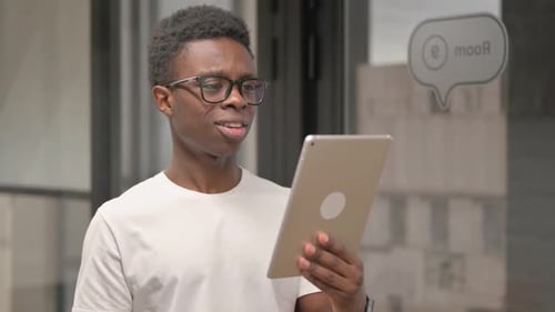 Young Man Video Conferencing with a Tablet in Office