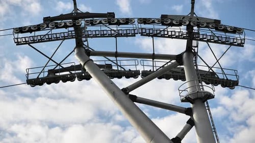 Industrial Detail of a Gondola Lift Pylon and Cabin Against a Cloudy Sky