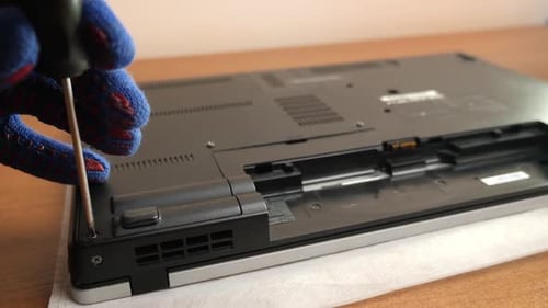 T133. The wizard removes the back cover of the laptop case. PC care and repair concept.