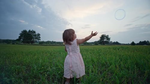 Slow Motion Video of a Baby Girl and a Soap Bubble