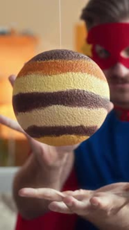 Vertical d'un homme en costume de super-héros tenant la planète dans ses mains
