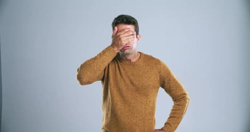 Erreur, échec et gêne sur la paume de la main avec un homme en studio avec stupide, regret et fond gris