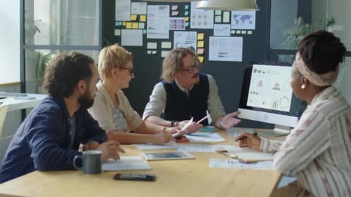 Geschäftsmann erklärt dem Team Finanzgrafiken