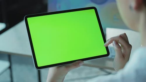 Back Shot of Unrecognizable Young Caucasian Woman Holding Electronic Tablet Touching Green Screen