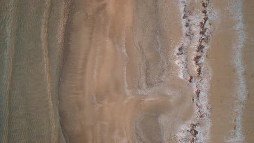 Lake Huron at sunset with gentle waves lapping the sandy shore, aerial view