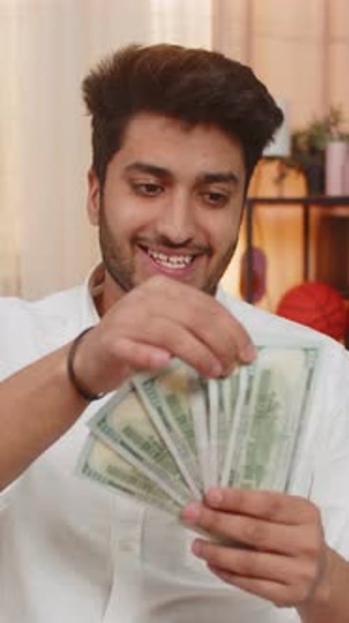 Indian Young Man Carefully Counting Cash Dollars Thoughtfully Planning Expenses Managing Money