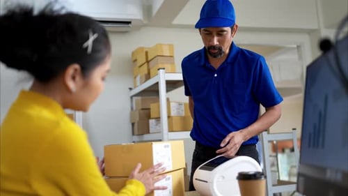 A female warehouse worker is receiving packages and verifying shipping information