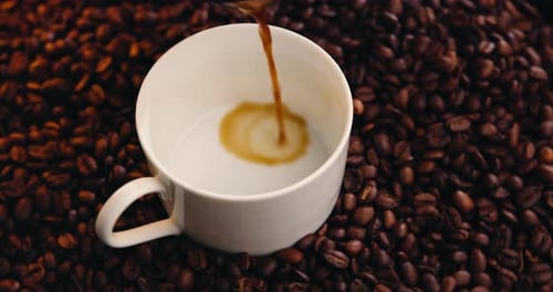Coffee Beans and White Cup with Coffee Pouring