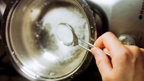 Adding Spoonful of Sugar to Metal Bowl