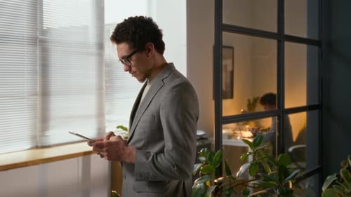 Young Male Entrepreneur Managing Emails on Digital Tablet Working in Office