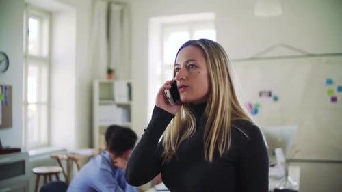 Young businesswoman works with smartphone in modern open office space