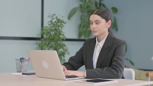 Businesswoman Smiling While Working on Laptop