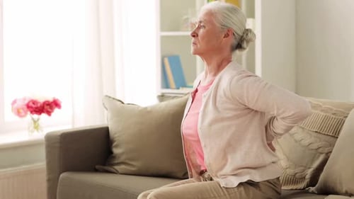 Senior Woman Sitting with Back Pain on Couch