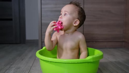 Happy Infant Bathing in Bright Green Tub