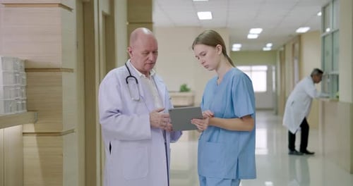 Doctor and Nurse Discussing Patient Information in Hospital