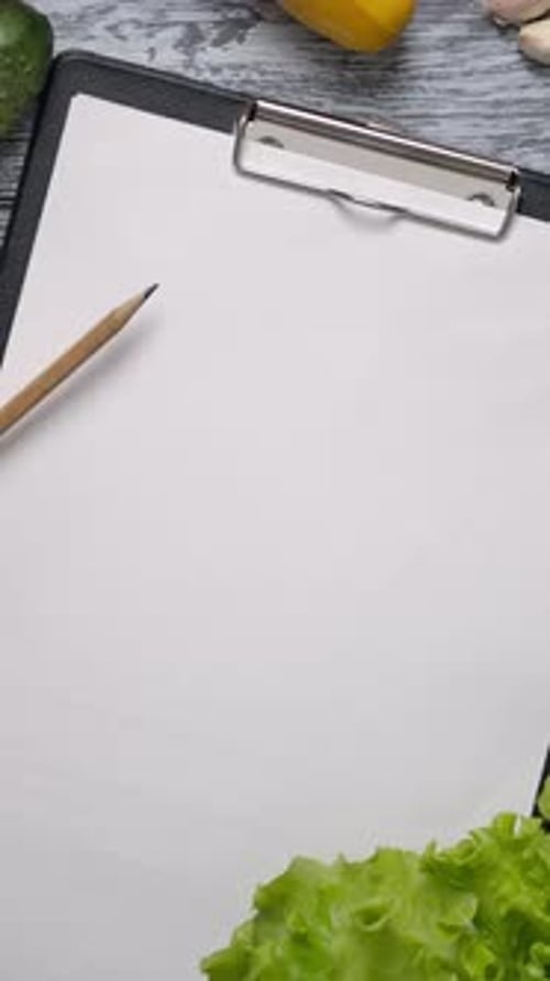 Vertical of Faceless Cook with Pencil Pointing at List of Ingredients